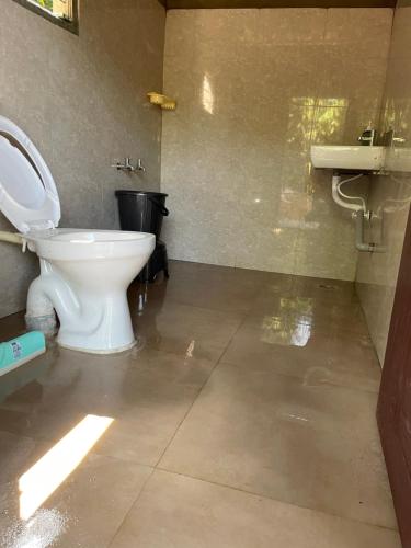 a bathroom with a toilet and a sink at Byrahalli Bliss riverside camping in Sakleshpur