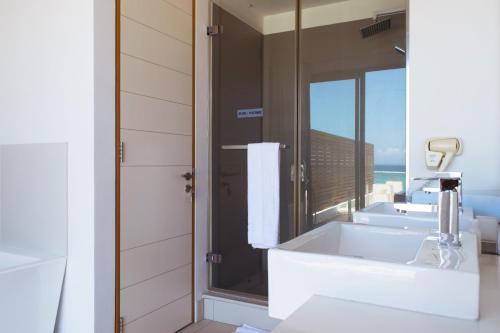 a bathroom with two sinks and a large mirror at Cap Ouest by Horizon Holidays in Flic-en-Flac