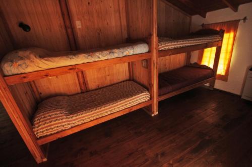 a room with two bunk beds in a cabin at Hostel Luz Clara in El Hoyo