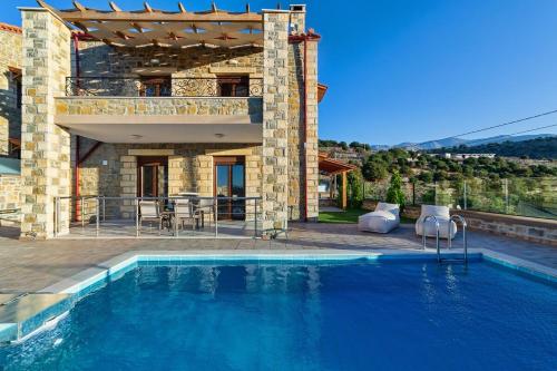 a swimming pool in front of a house at Asfendamos Villas in Zonianá