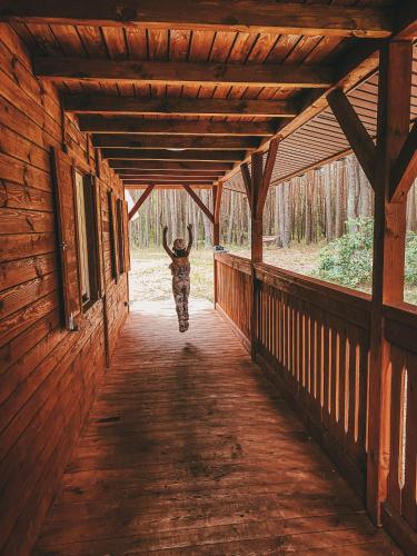 a deer walking down a hallway of a wooden building at Domki w Sosnowym Lesie in Rembów