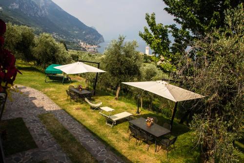 a group of tables and umbrellas in the grass at Agriturismo L'Uliveto in Gargnano