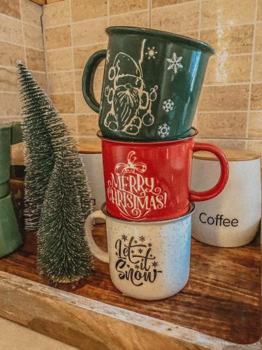 two coffee mugs sitting on a shelf with a christmas tree at Domki w Sosnowym Lesie in Rembów
