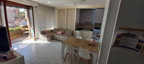 cocina pequeña y sala de estar con mesa y sillas en Bonaria Apartment, en Cagliari
