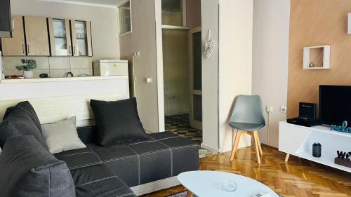 a living room with a couch and a kitchen at Majdini Clock Tower Apartman in Podgorica