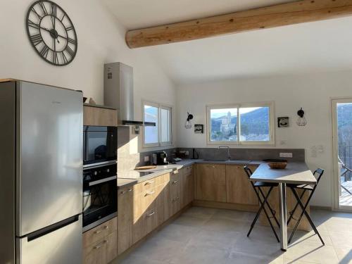 Pierrelongue的住宿－Le Mas No'Stelou，厨房配有冰箱、桌子和时钟