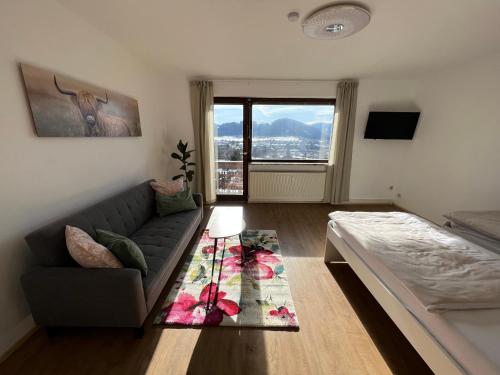 a living room with a couch and a large window at Wohnung Magdalena in Feldkirchen in Kärnten