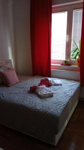 uma cama com toalhas num quarto com uma janela em Apartman Mira em Pozarevac
