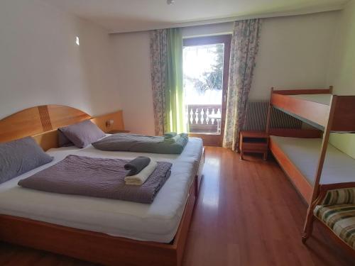een slaapkamer met 2 bedden en een raam met een balkon bij Landhotel Oberwengerhof in Spital am Pyhrn