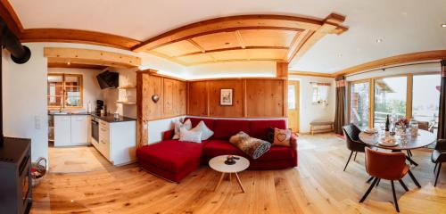 普夫龍滕的住宿－Babel´s Auszeit，客厅配有红色的沙发和桌子