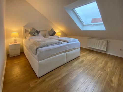 a bedroom with a large white bed with a skylight at 4 Zimmer Apartment, 125 qm, ruhig und zentrumsnah, max 5 Pers, Dachterasse, Garage, 1000 MBit in Böblingen