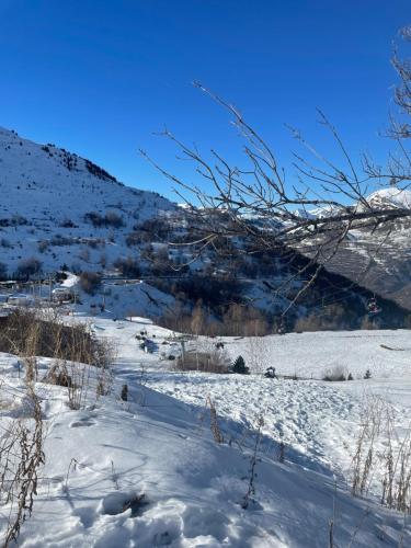 a snow covered field with a mountain in the background at Petit appartement Labellisé Les 2 Alpes résidence Arc en Ciel télésiège Petite Aiguille in Les Deux Alpes