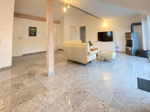 a living room with a couch and a chair at 4 Zimmer Apartment, 125 qm, ruhig und zentrumsnah, max 5 Pers, Dachterasse, Garage, 1000 MBit in Böblingen