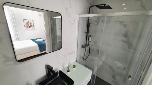 ein Badezimmer mit Dusche, Waschbecken und Spiegel in der Unterkunft Seasons Porto-Gaia by MyStay in Vila Nova de Gaia