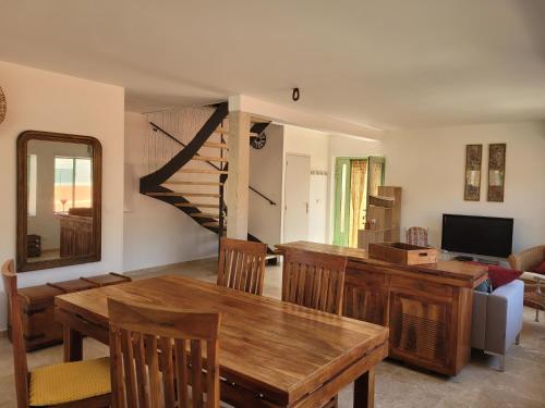 een woonkamer met een houten tafel en een bank bij Gîte l'atelier de Phil et Delfe in Sainte-Cécile-les-Vignes