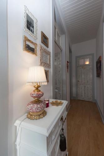 a lamp on a white table in a hallway at Casa Dourada in Barcelos