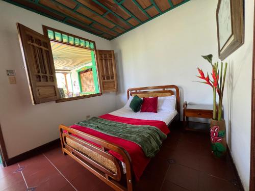 a bedroom with a bed in a room with a window at Casa Lemar in Quimbaya
