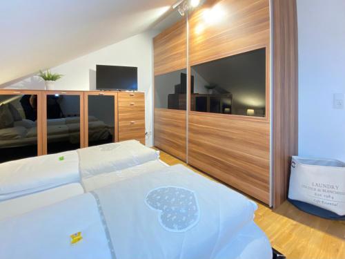 a bedroom with a large bed and a television at 4 Zimmer Apartment, 125 qm, ruhig und zentrumsnah, max 5 Pers, Dachterasse, Garage, 1000 MBit in Böblingen