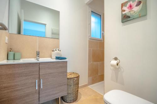 ein Bad mit einem Waschbecken und einem WC in der Unterkunft Pretty air-conditioned house with flower garden in Plan-de-la-Tour
