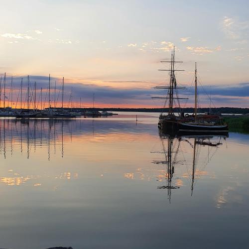 a sail boat sitting in the water at sunset at Epokgården in Öregrund