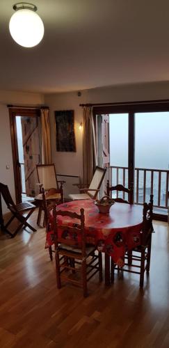een woonkamer met een tafel, stoelen en ramen bij Soldeu Paradis Tarter Mig in El Tarter