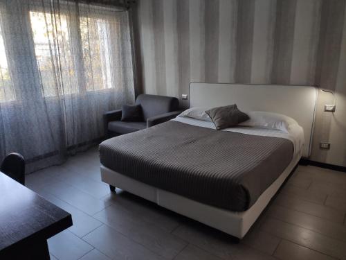 ein Schlafzimmer mit einem Bett und einem Stuhl darin in der Unterkunft B&B Il Granello Di Senape in Rom