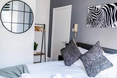 a bedroom with a bed with black and white pillows at Chic Studio Apartment in Prime London Location in London