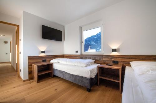 1 dormitorio con 2 camas y ventana en Apartment Villa Hetty, en Ortisei