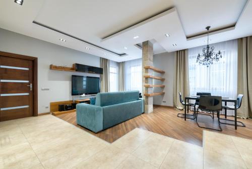 a living room with a blue couch and a table at Dom & House - Apartment Neptun Park Premium in Jelitkowo