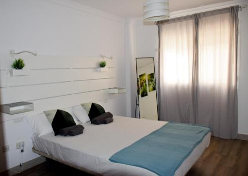 a bedroom with a white bed with a blue blanket at Blue waves - free parking in El Médano