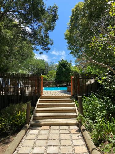 a wooden walkway leading to a pool with a fence at Badger's Lodge in Knysna