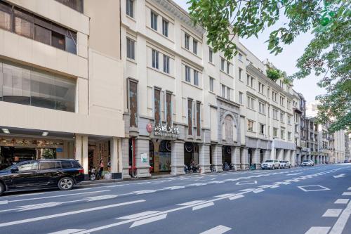 una calle con coches estacionados en el lateral de un edificio en Guangzhou Hongcheng Hotel en Cantón