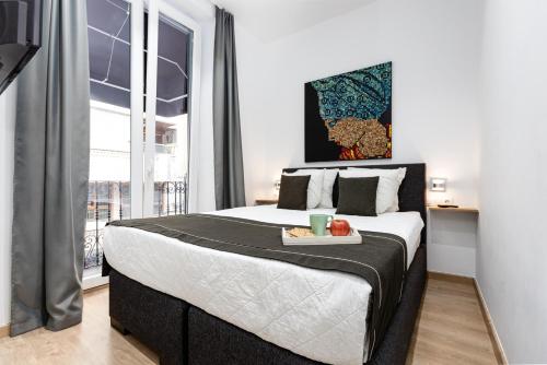 a bedroom with a bed with a tray of food on it at Pinzon Studios & Penthouse in Alicante