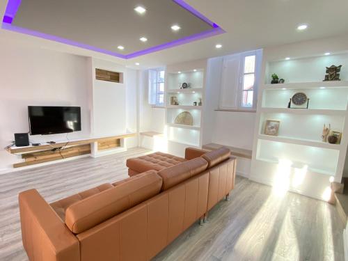 a living room with a couch and a flat screen tv at Amazing Setúbal in Setúbal