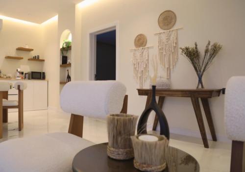 a living room with white chairs and a table at Quiet House villa in Hatta