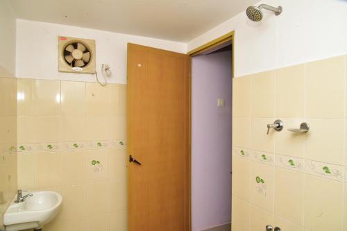 TellicherryにあるBella Apartmentsのバスルーム(シンク、木製のドア付)