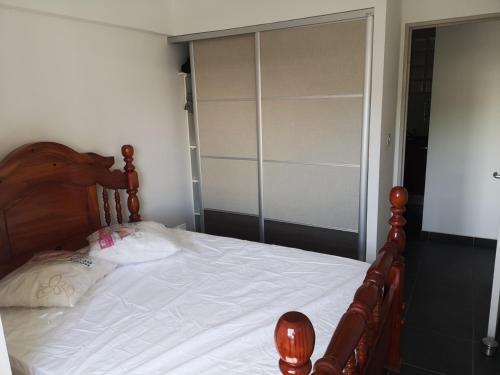 a bedroom with a large bed with a wooden headboard at Cap Au Soleil in Saint-Pierre