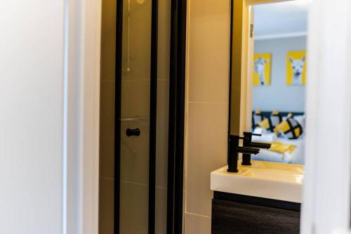 a bathroom with a shower and a sink and a mirror at Charming Studio Retreat I1Bed1Bath Haven in London in London