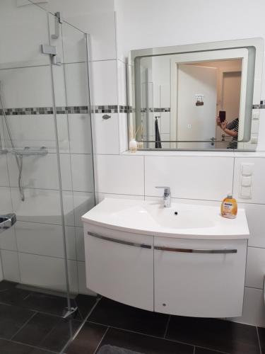 y baño con lavabo blanco y espejo. en Ferienwohnung MeerBlick OG, en Altefähr