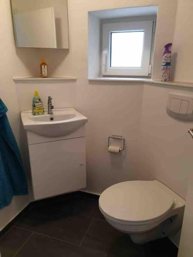 a bathroom with a white toilet and a sink at Bungalow 3-Zimmer / Wlan / Garten / Parkplatz in Stadt Schenefeld