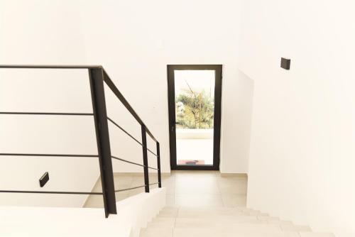 a staircase in a white house with a window at Villa Mouria private villa just 200m from the sea in Pogoniá