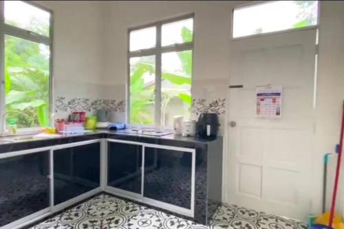 cocina con encimera, ventana y puerta en Amy Homestay-Suasana kampung yang nyaman, en Pasir Mas