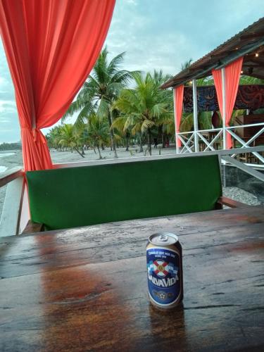 a can of beer sitting on top of a wooden table at Hostel Casa Verde, Tela Atlantida. in Tela
