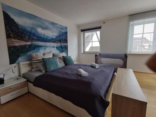 a bedroom with a large bed with a painting on the wall at Apartment close to Lake Ferienwohnung Seenah in Sipplingen