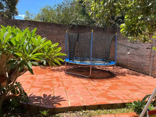 a trampoline with a net on a brick patio at Casa con piscina y parque in Garupá
