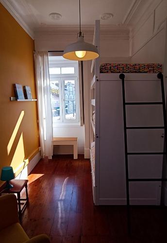 a living room with a staircase and a window at Aveiro Rossio Hostel in Aveiro