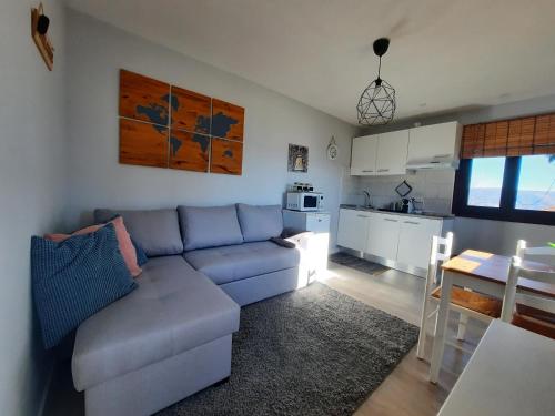 a living room with a couch and a kitchen at Casinha do Cedro in Baião