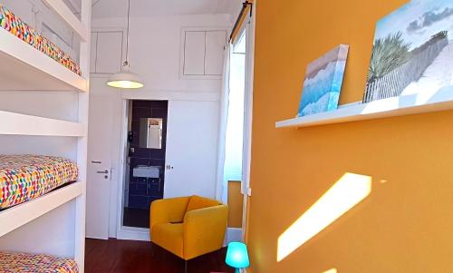 a room with a bed and a yellow chair at Aveiro Rossio Hostel in Aveiro