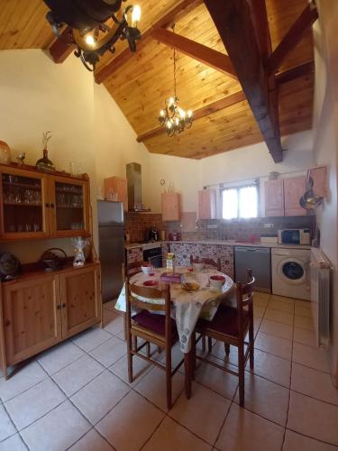 une cuisine avec une table et des chaises dans une pièce dans l'établissement Aux 4 mousquetaires Athos, à Capvern