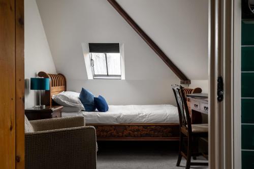 a bedroom with a bed with blue pillows on it at St Johns House Lichfield in Lichfield